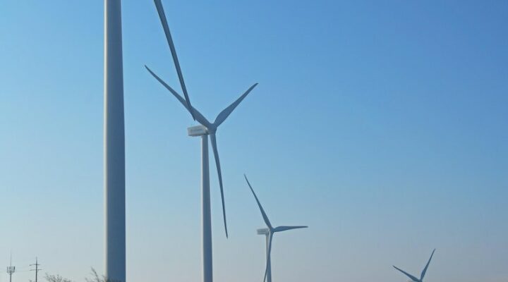 Car Parked Near Wind Turbines Under Blue Sky